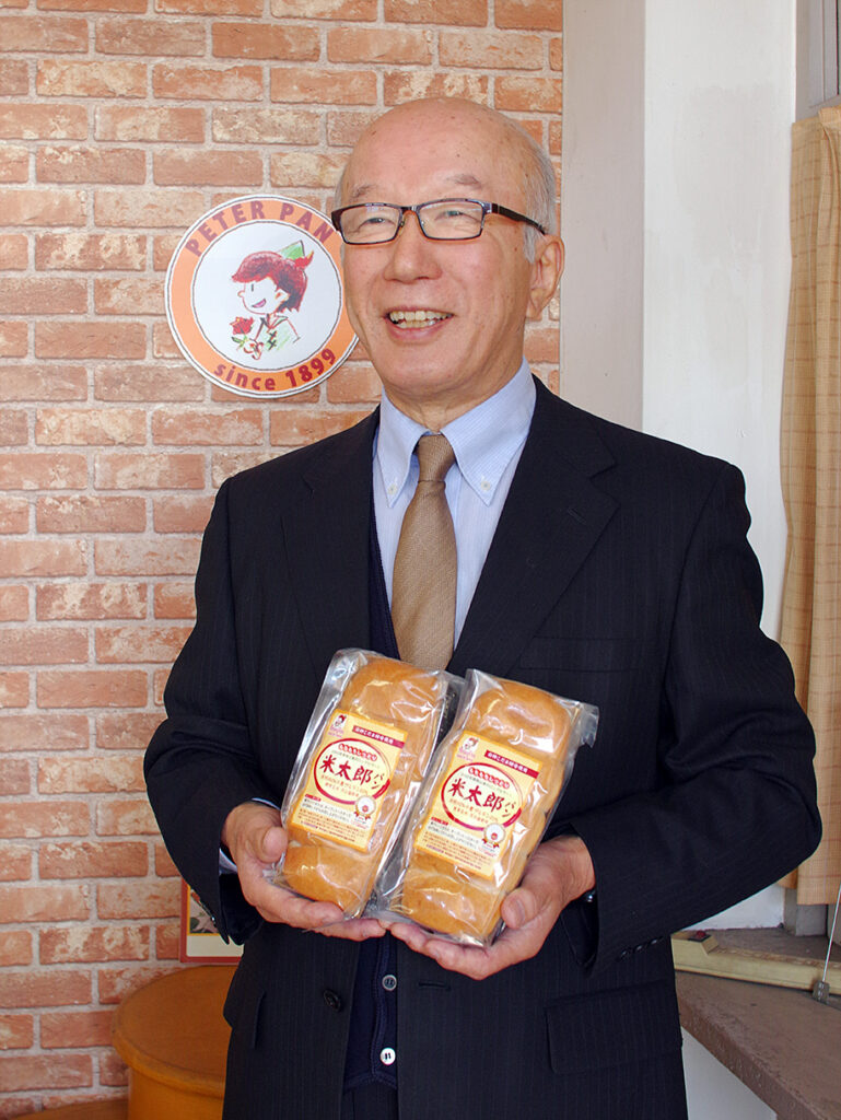 株式会社ピーターパン社長廣川徹。自社の無添加米粉パンを持って。